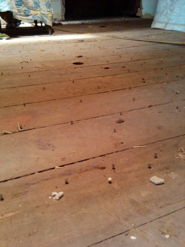 pulling nails from old pink plank flooring